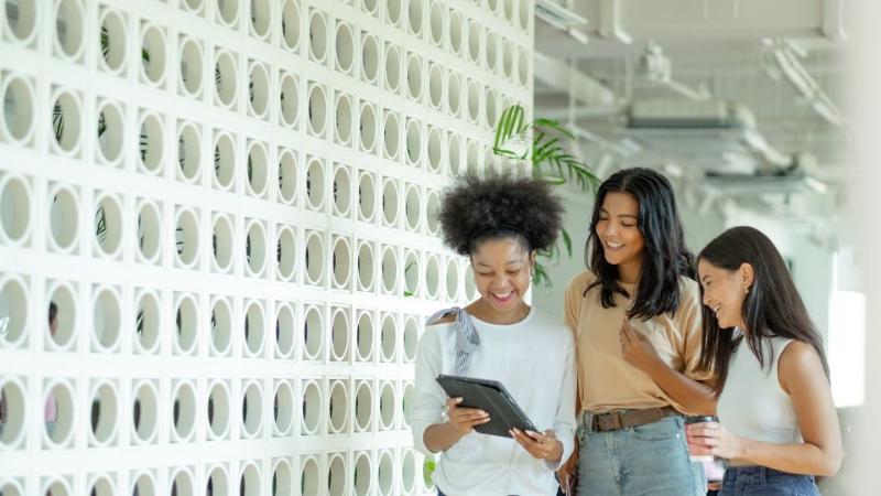 three females standing together chatting